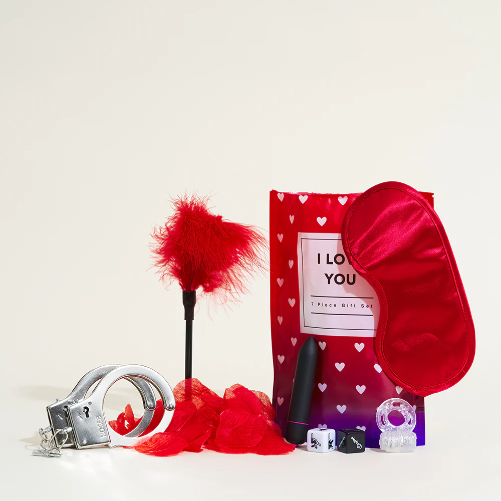 Pochette surprise romantique contenant des accessoires discrets comme des menottes en satin.