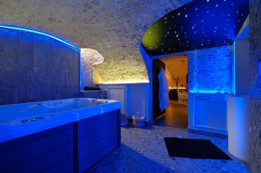 Suite romantique avec plafond voûté en briques, éclairage d'ambiance et jacuzzi à Mons