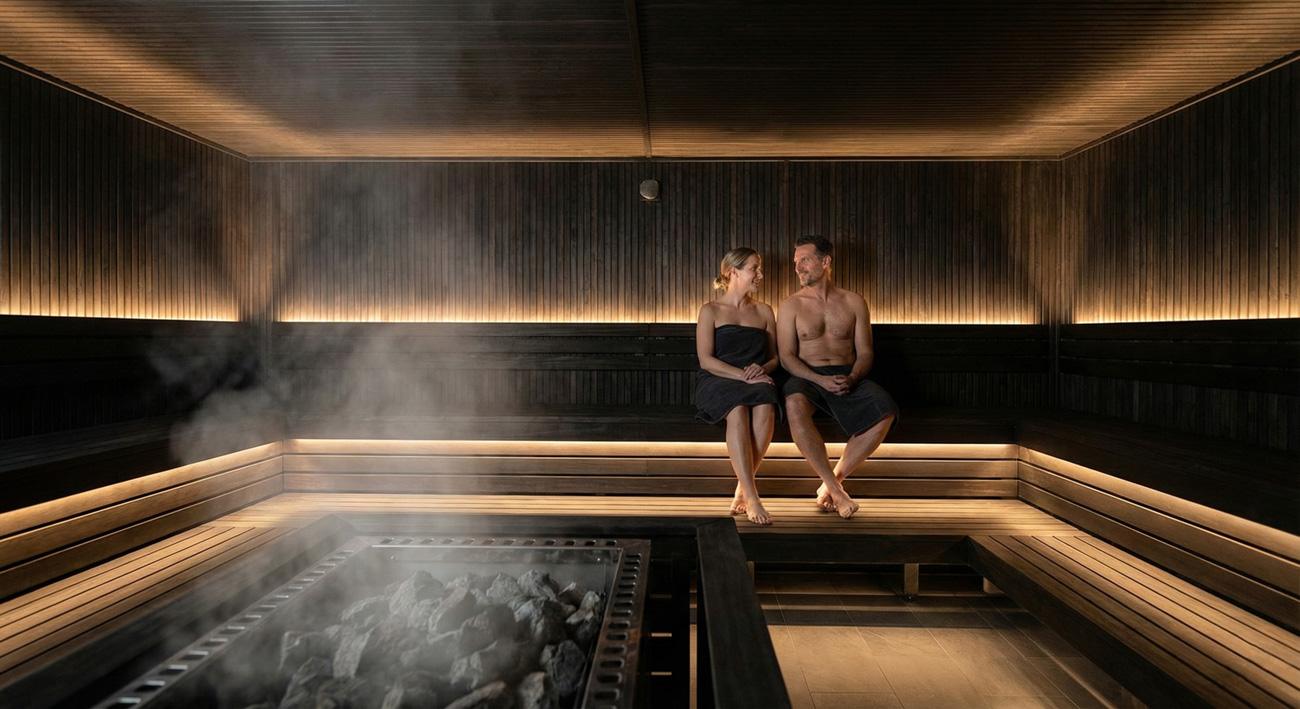 Couple détendu dans un sauna en bois moderne (Illustration pour avis Waer Waters)